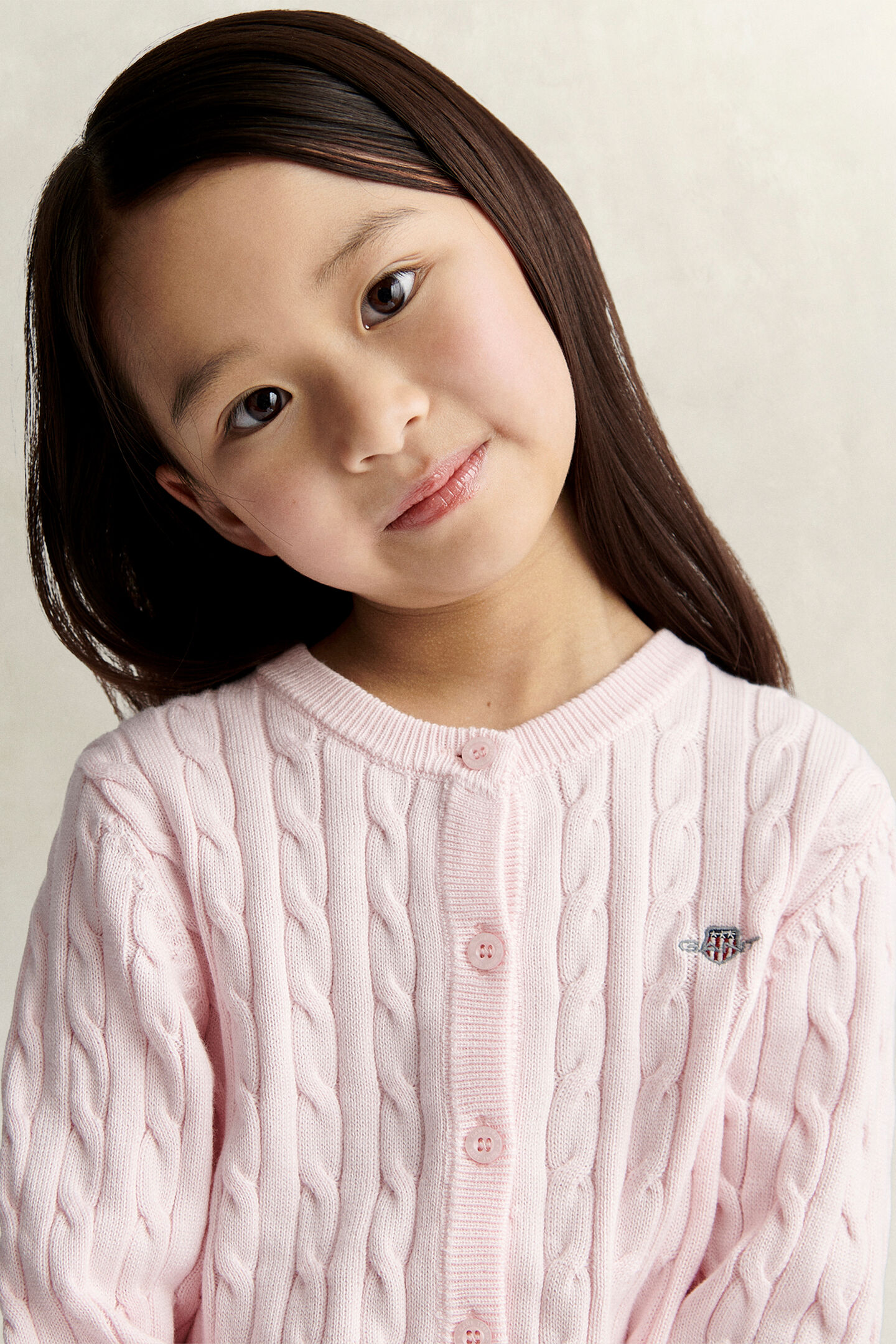 Girls kabelstickad kofta med sk&ouml;ldemblem